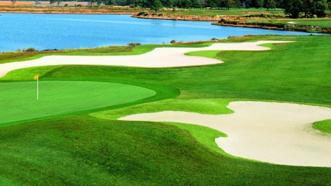 Newport Bay — the 18th green, sculpted bunkers, and the bay behind