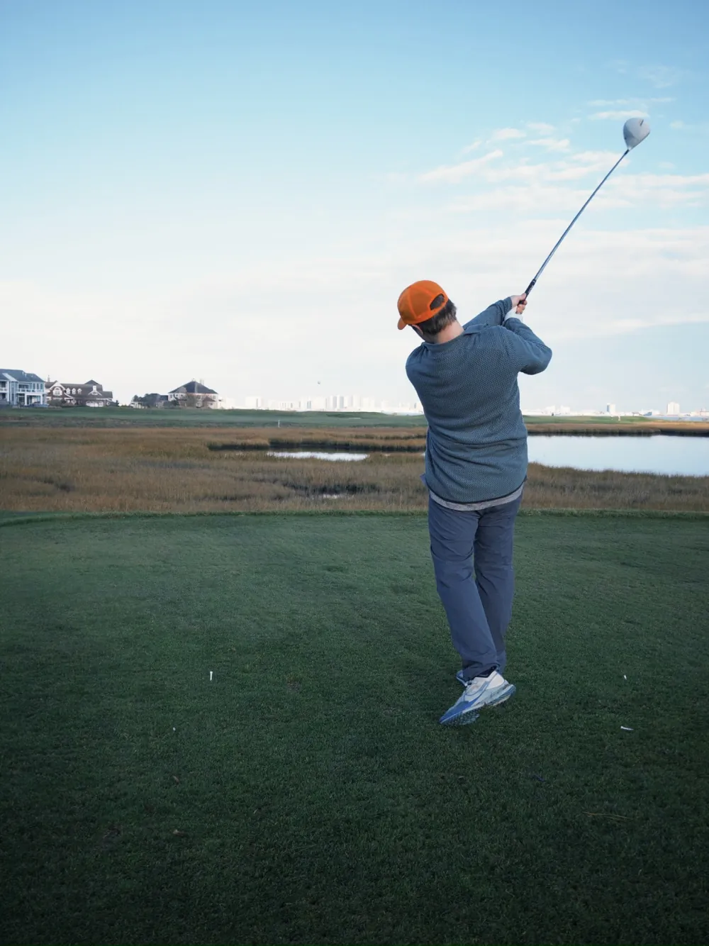 Mid-swing on a cold, wind-bent morning by the marsh