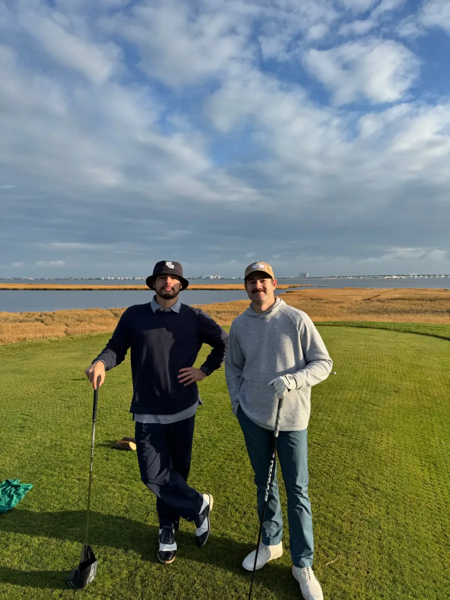 Two on the tee in the last good light, the bay at their backs