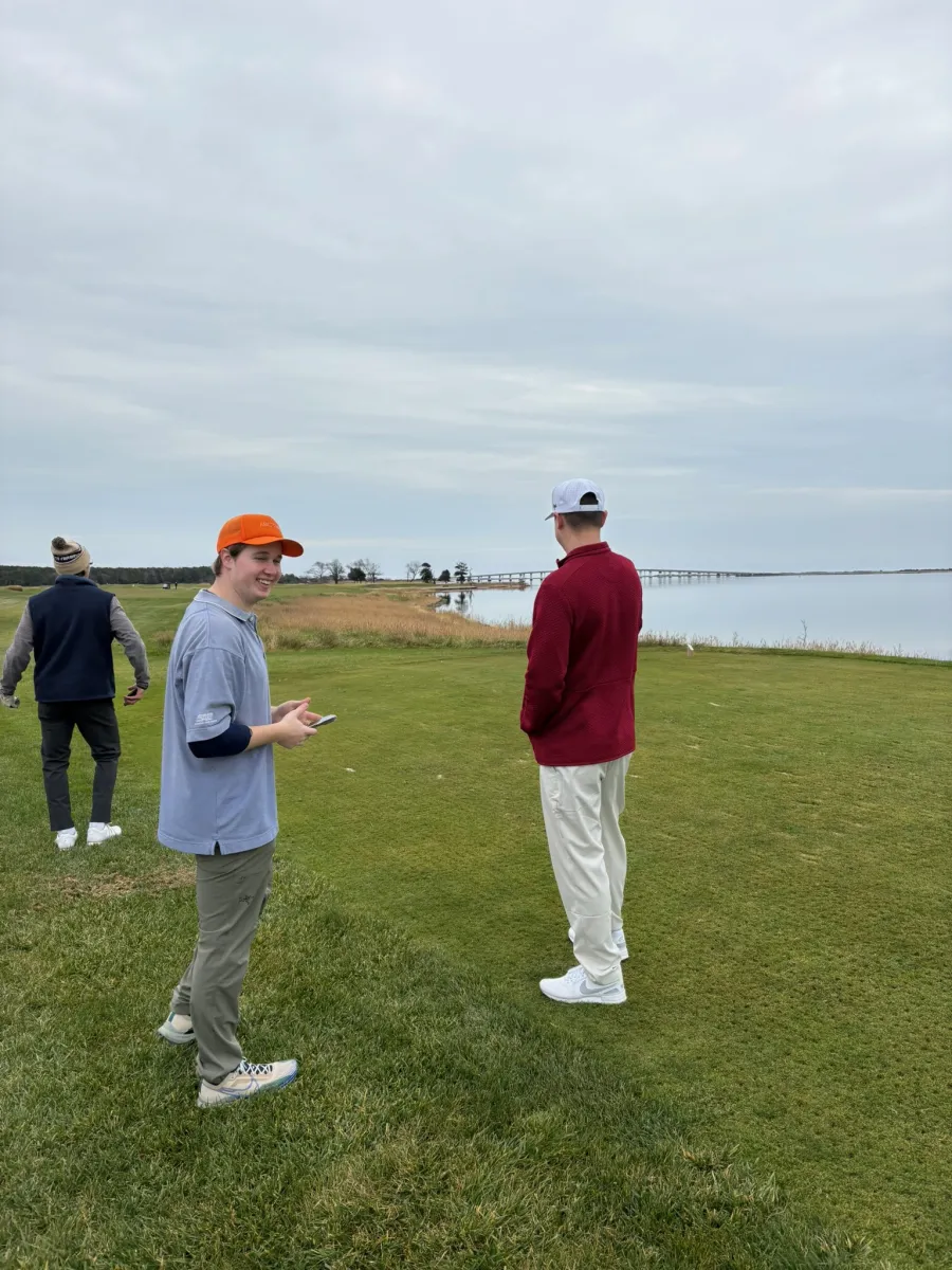 Two of the group talking it over on the tee, a bridge in the distance