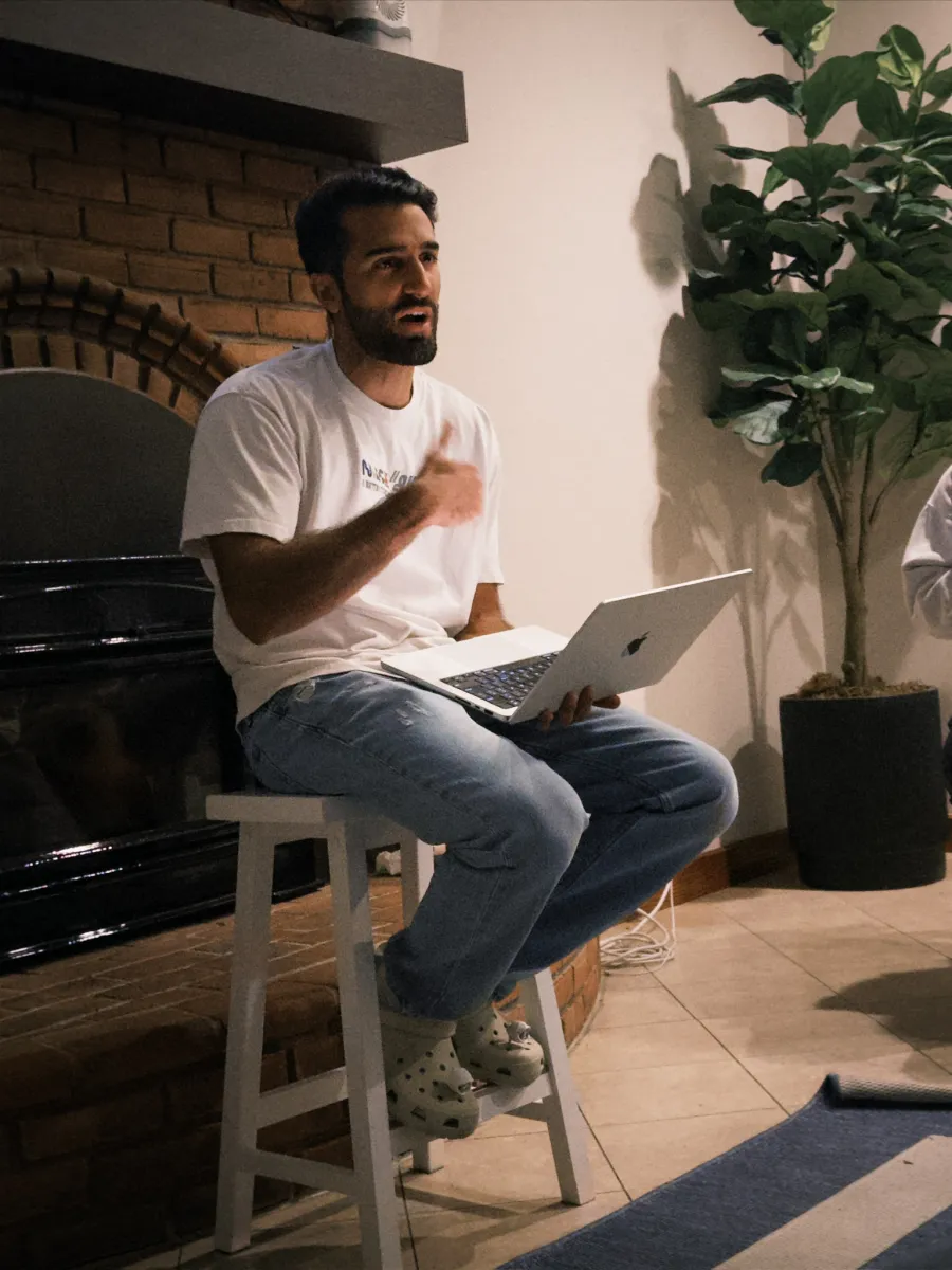 Holding court by the fire, laptop out, hand up mid-point